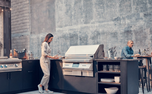 Woman standing next to built-in Pellet Grill